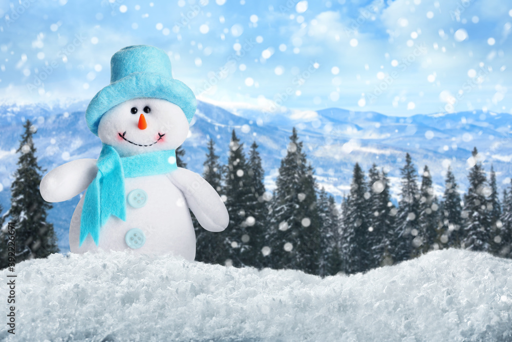 Fototapeta premium Cute toy snowman in winter forest. Space for text