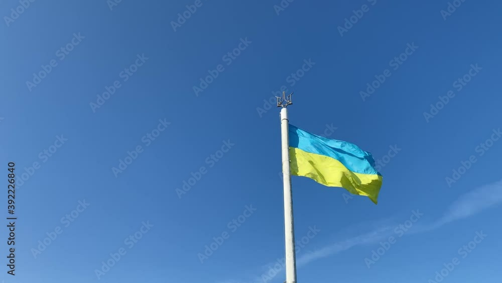Ukraine national flag is waving in wind against blue sky. Big yellow blue patriotic Ukrainian state flag in National Holiday Independence, Flag, Constitution Day. side lighting. Ukraine national flag is waving in wind against blue sky. Big yellow blue patriotic Ukrainian state flag in National Holiday Independence, Flag, Constitution Day. side lighting.