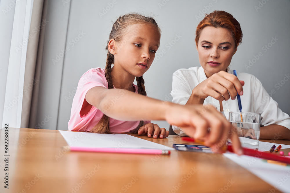 Girl drawing picture together with her mother Girl drawing picture together with her mother
