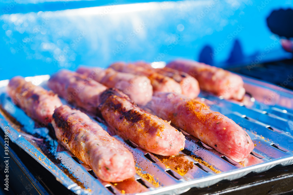 Sausages meat grilling on gas grill