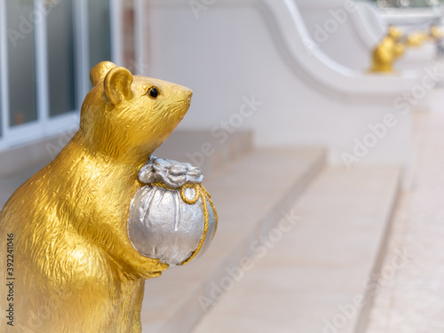 Golden Zodiac Rat Statue Stands Holding The Silver Money Bag photo