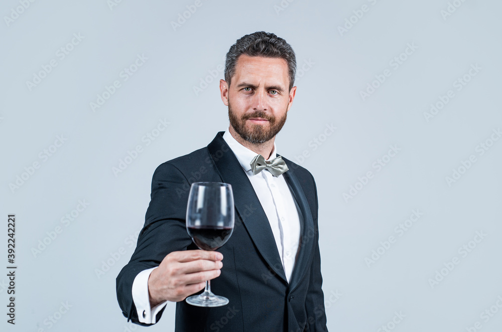 Naklejka premium man wear office costume. formal event. businessman drink red wine. cheers for happy valentines day. alcohol drinking. handsome male on romantic date. unshaven man with wine glass. sommelier