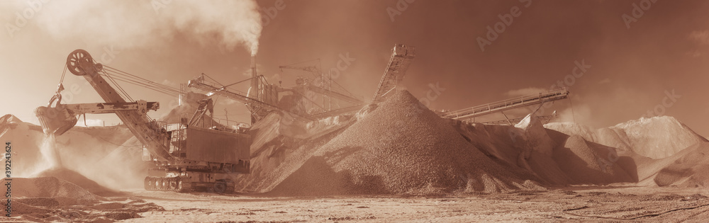 Obraz premium Excavator on the background of stone-crushing equipment at the limestone quarry, monochrome panoramic image of a light brown color, sepia. Mining industry.
