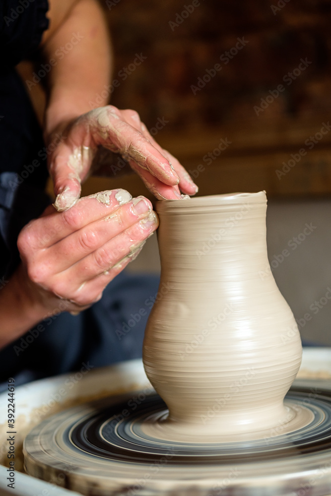 Female hands working with clay on a potter's wheel Female hands working with clay on a potter's wheel