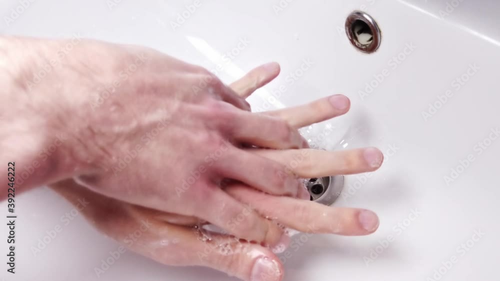 Man washing hands with green liquid soap in the bathroom Man washing hands with green liquid soap in the bathroom