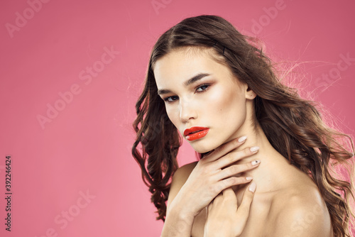 Beautiful woman with red lips on a pink background nude shoulders cropped view
