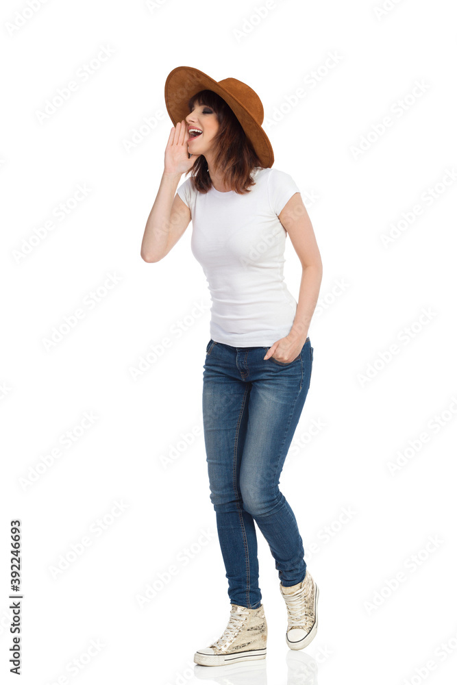 Young Woman Is Standing, Holding Hand On Chin And Shouting Young Woman Is Standing, Holding Hand On Chin And Shouting