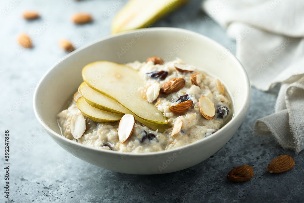 Oatmeal porridge with nuts, raisins and fresh pear