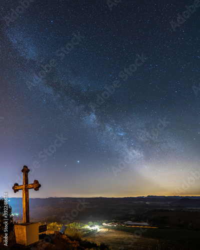 milky way night landscape with cross religion and town