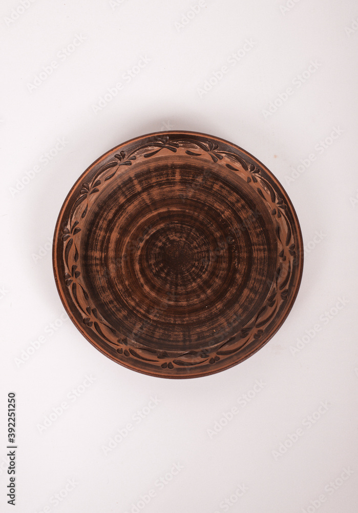 Ceramic ware isolated on a white background. Single rustic clay plate. 