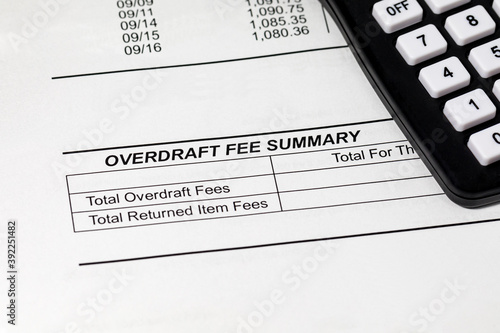 Closeup of bank statement for checking account and calculator. Concept of wealth, debt and money problems.
