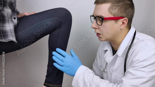 The woman suffers from pain in the calf mouse. Knee treatment concept for trauma, myositis, nerve damage or osteoarthritis. Doctor examines photo