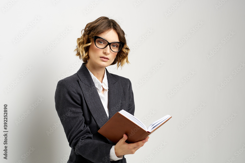 Business woman in a classic suit with a notebook in her hand and glasses on her face Copy Space