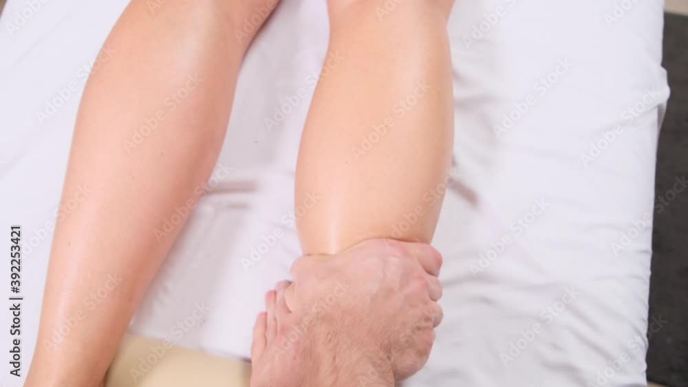 Extreme close up of osteopath applying pressure with thumb on female calf muscle. Extreme close up of osteopath applying pressure with thumb on female calf muscle.