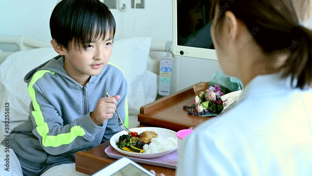 看護師の指導を受けながら入院食を食べる患者の男の子 看護師の指導を受けながら入院食を食べる患者の男の子