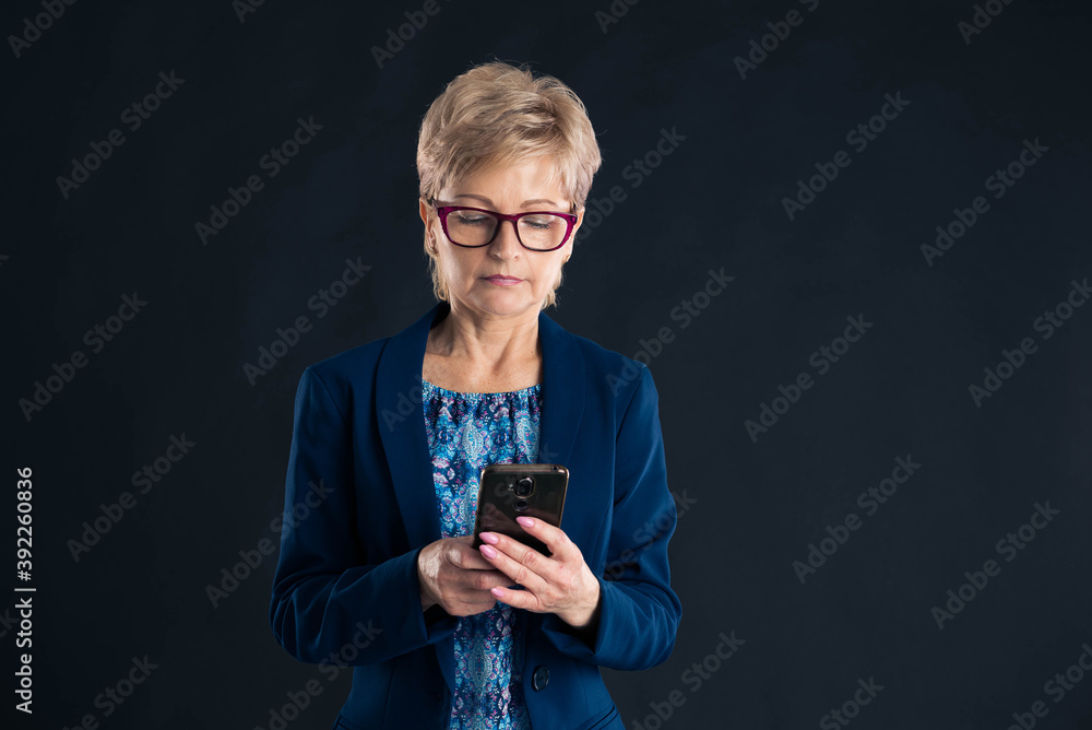 Older businesswoman texting on her mobile phone Older businesswoman texting on her mobile phone