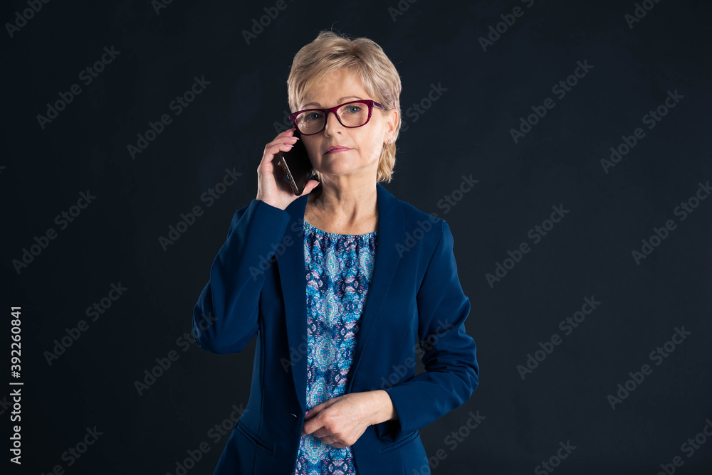 Older businesswoman talking on her cellphone Older businesswoman talking on her cellphone