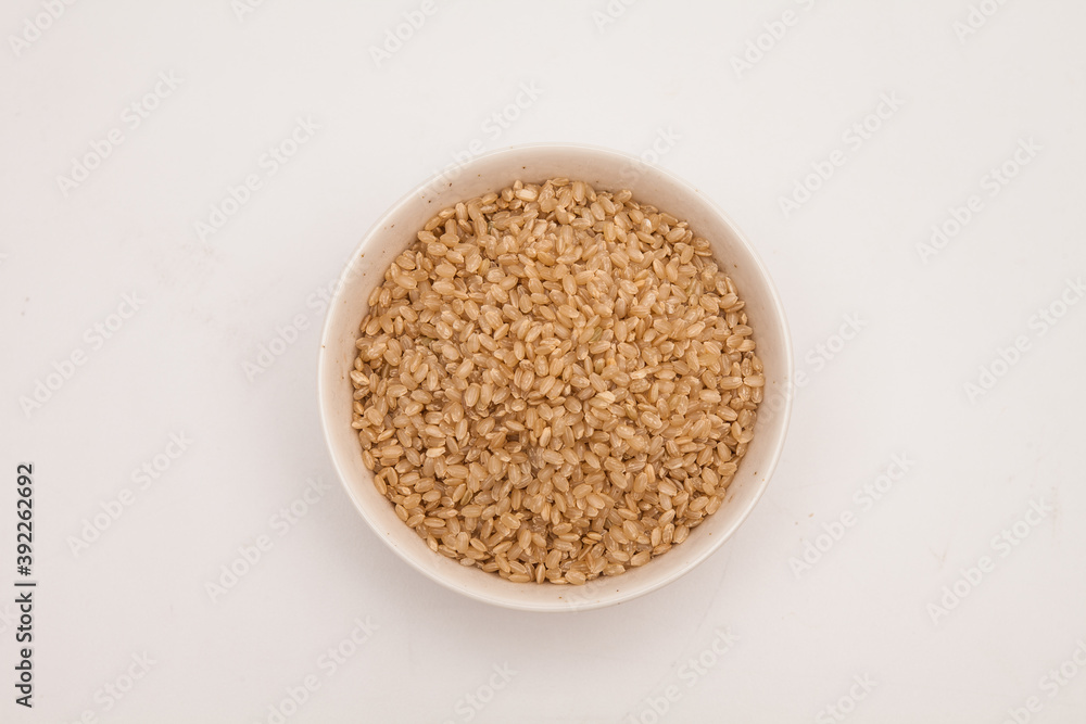 Brown rice, unpolished rice in a white bowl Brown rice, unpolished rice in a white bowl