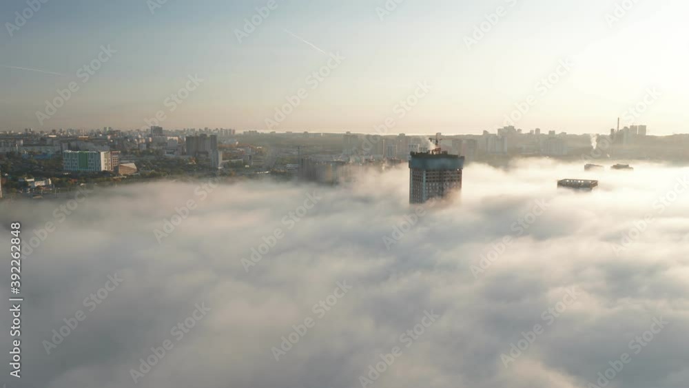 Drone shot into the thick fog at sunrise over buildings. High quality 4k footage Drone shot into the thick fog at sunrise over buildings. High quality 4k footage