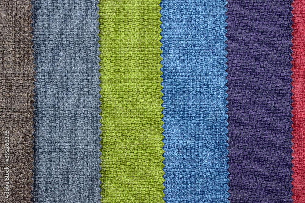Fototapeta premium Upholstery fabric in different colors, top view. Thick fabric texture. A set of fabrics for furniture.