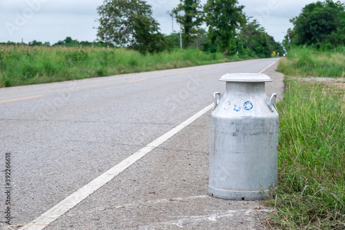 A bucket of raw milk is placed on the roadside waiting to be transported into the factory.