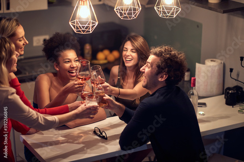 Canvas Print gathered group of friends toasting, drinking wine and beer