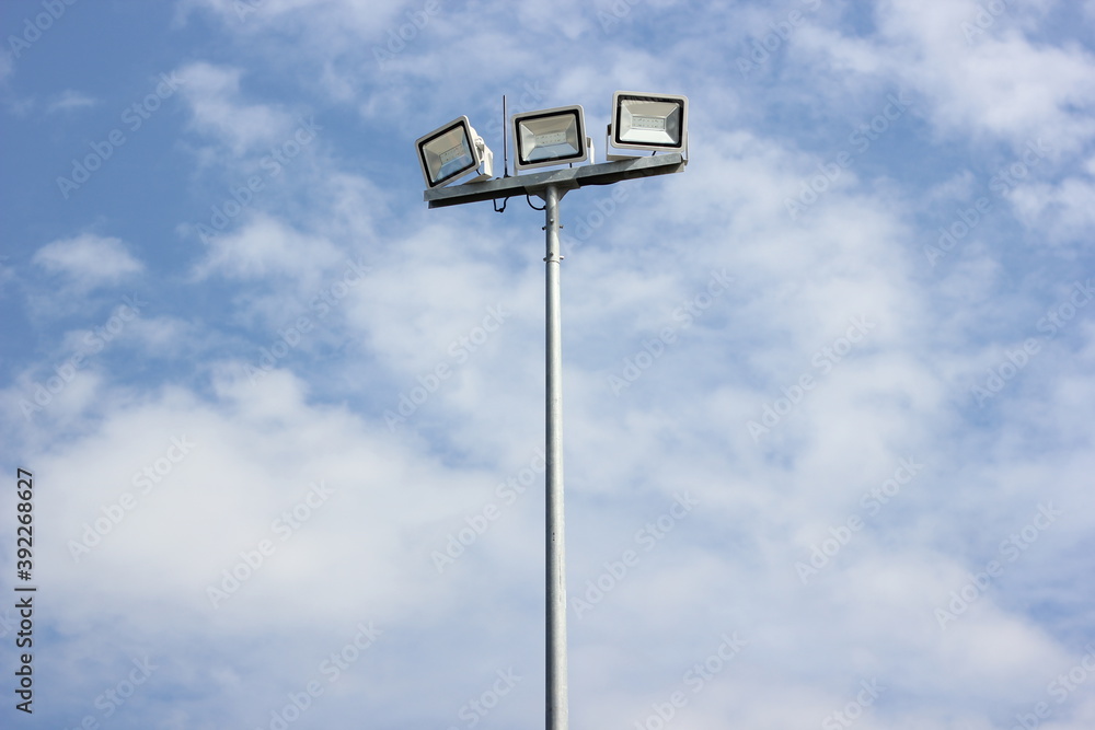 Spotlight pole, Power poles and sport light with blue sky and clouds background. Spotlight pole, Power poles and sport light with blue sky and clouds background.