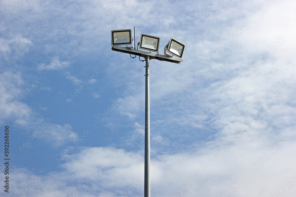 Spotlight pole, Power poles and sport light with blue sky and clouds background. Spotlight pole, Power poles and sport light with blue sky and clouds background.