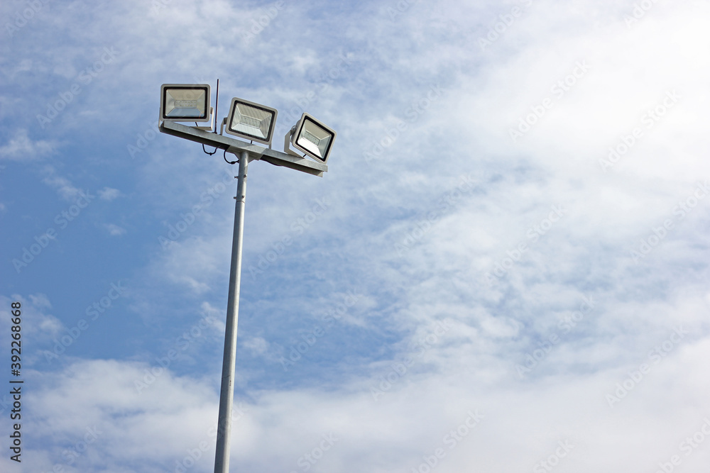 Spotlight pole, Power poles and sport light with blue sky and clouds background. Spotlight pole, Power poles and sport light with blue sky and clouds background.