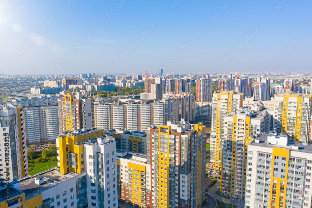 Panoramic aerial view of the city with multi storey residential buildings and highways.