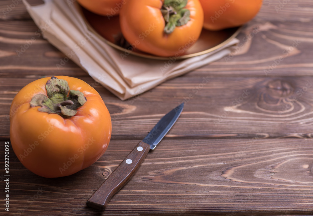 Delicious fresh persimmon fruit on wooden table.