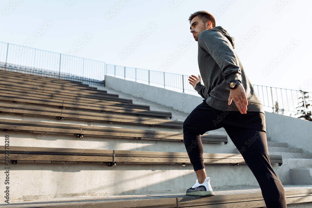 Sporty man, in sportswear, jogging while training outdoors on the city stairs, sport, healthy lifestyle