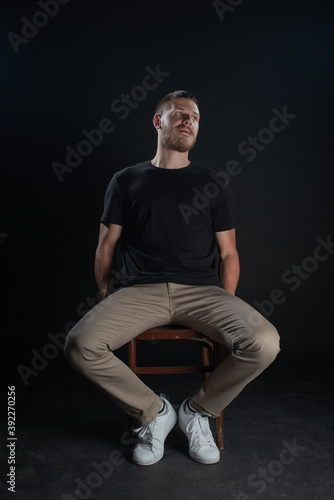 Dramatic portrait of a serious guy while posing in studio on black background. Isolated Depressed face expression