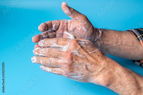 Someone washing hands with soap close up. Coronavirus protection and cleanliness and body care concept.