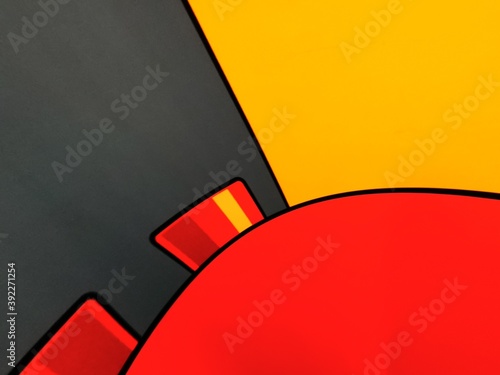 vivid yellow and bright red coloured building block on dark grey background photo