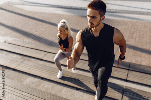 Sporty young couple  man and woman running together on the city stairs  sport  healthy lifestyle