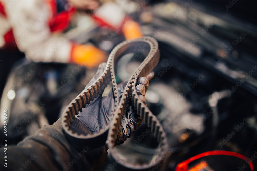 automotive timing belt in the hand of an auto mechanic.