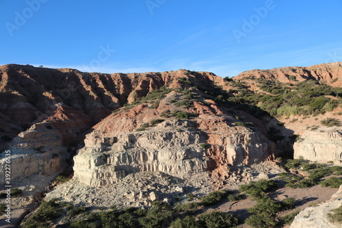 Vista de curiosas formaciones geol  gicas  con tonos rojizos  con rocas de la   poca prehist  ricas  durante el atardecer.