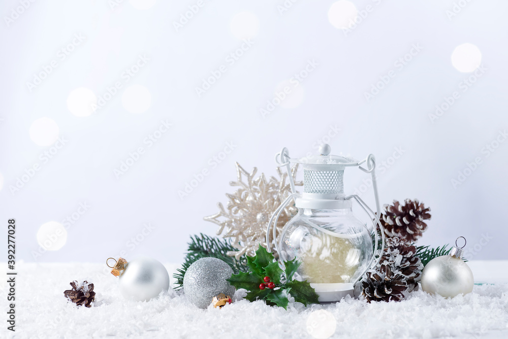 Christmas lantern on snow with fir branch and winter decoration on white Christmas lantern on snow with fir branch and winter decoration on white