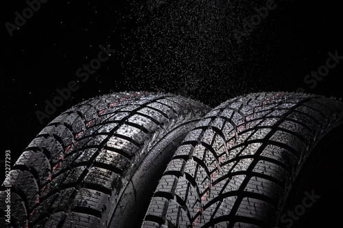 Winter Car tire and rain drops on black background