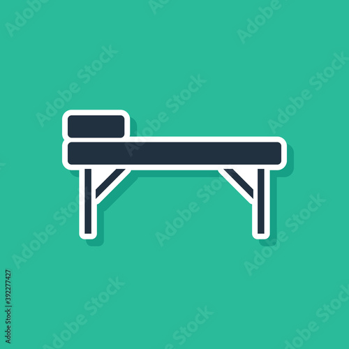 Blue Massage table icon isolated on green background. Vector.