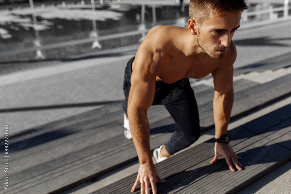 Obraz premium Athletic muscular shirtless man working out outdoors, sport, motivation