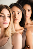african american and asian women near blonde model on blurred foreground