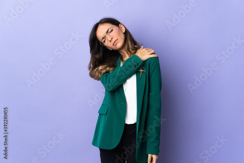 Young caucasian woman isolated on purple background suffering from pain in shoulder for having made an effort
