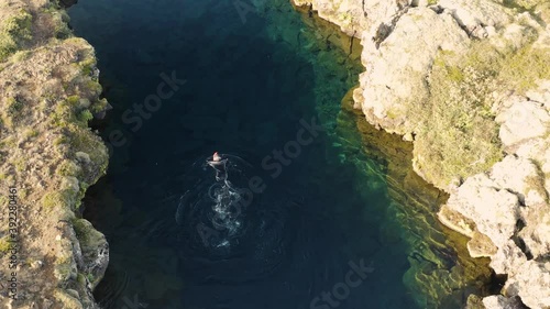 Aerial: Snorkeler swimming in Silfra popular diving / snorkeling fissure in Iceland between Eurasian and North American tectonic plates Thingvellir national park Phenomenal water clarity