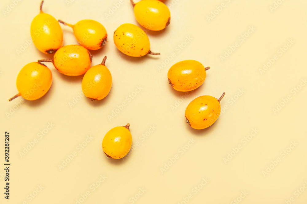 Fresh ripe sea buckthorn on beige background close-up. Background of ripe berries. Macro photography. Fruit organic background. Healthy food, vitamin berry