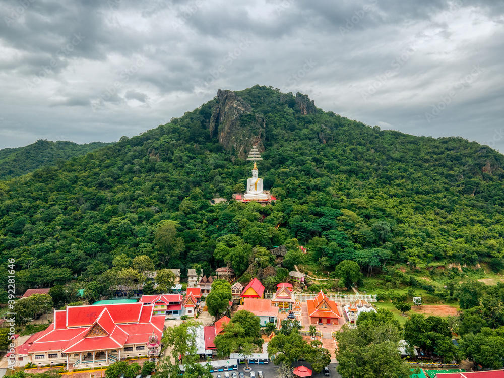 Mueang Lop Buri District, Lopburi / Thailand / October 10, 2020  : Wat Siri Chanthanimit Worawihan and Big white buddha statue with royal umbrella on a mountain.