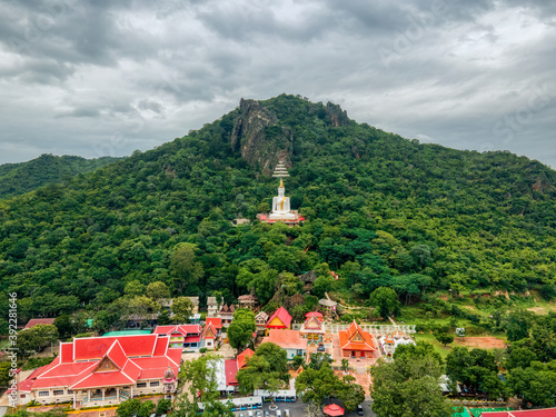 Mueang Lop Buri District, Lopburi / Thailand / October 10, 2020 : Wat Siri Chanthanimit Worawihan and Big white buddha statue with royal umbrella on a mountain.