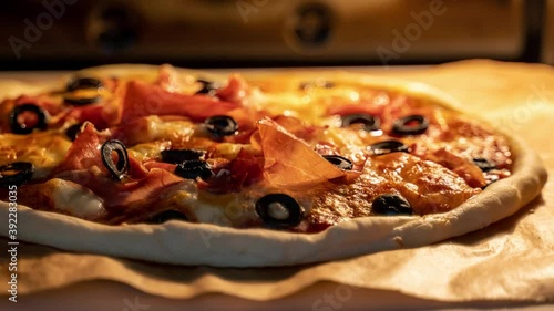 Timelapse of classic Italian pizza with prosciutto baking in an oven.  Trucking camera motion