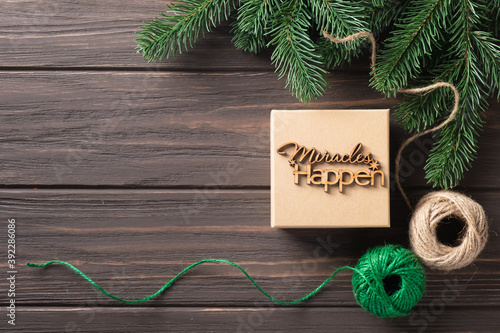 Christmas gift box with wooden lettering miracles happen. Gifts wrapping ideas. Natural design. photo